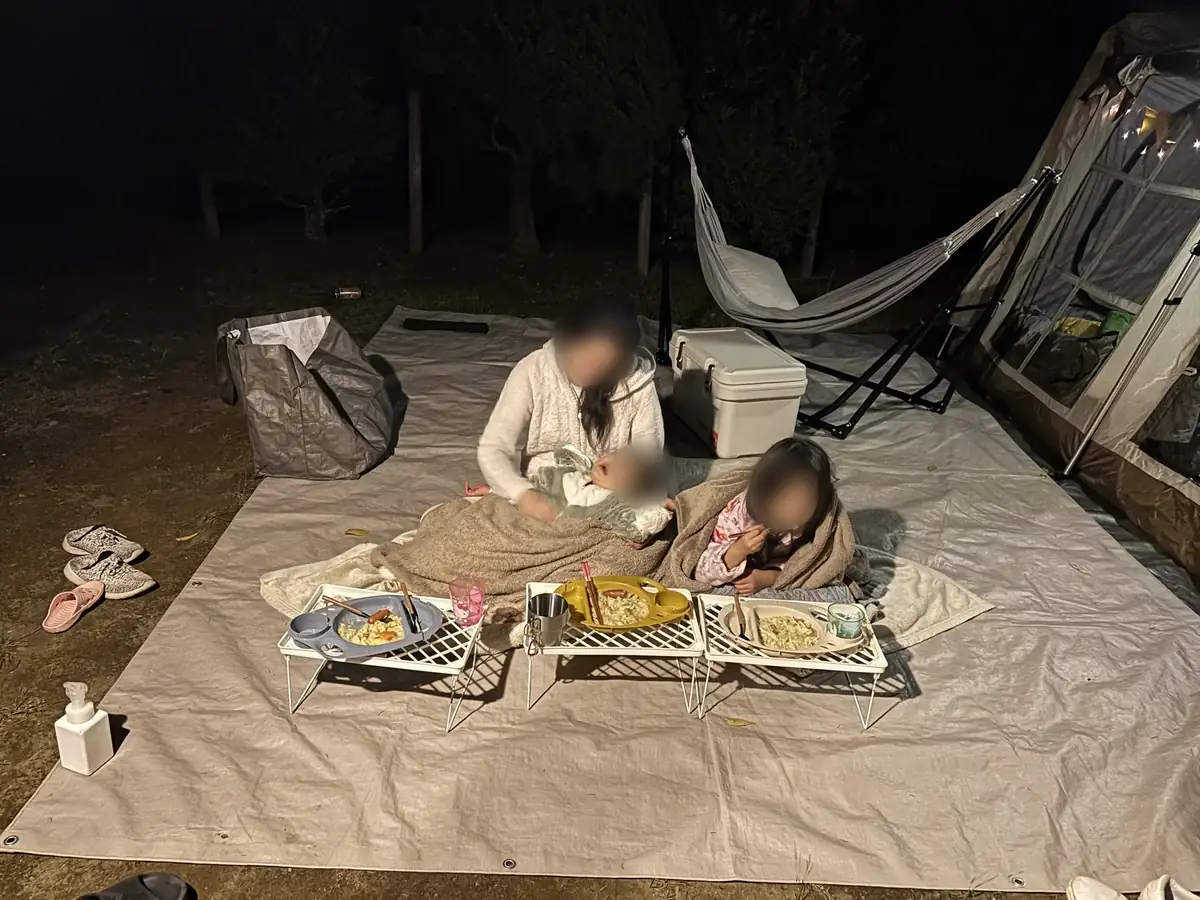 11月の内浦山県民の森キャンプ場で毛布にくるまりながら夕食を食べる子どもたち