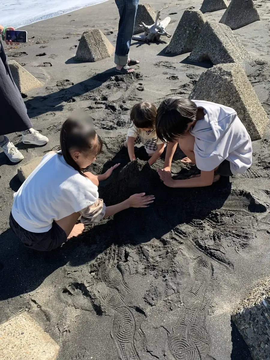 仲良くなった女の子2人と長女が砂浜で遊ぶ様子