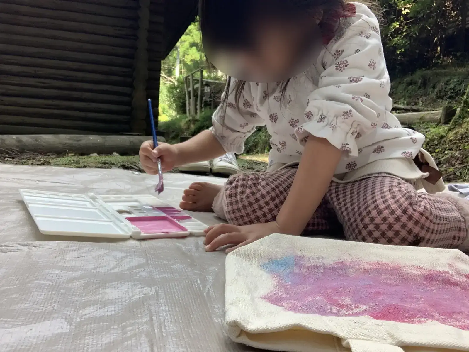 大多喜県民の森のテント前で絵の具遊びをする子ども