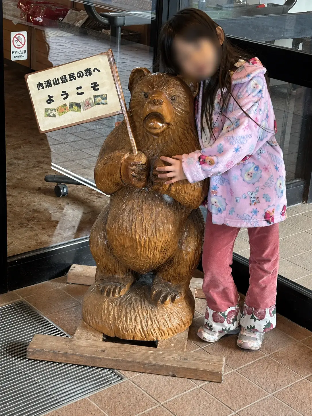 内浦山県民の森の入口で木彫りの熊と写真を撮る子ども