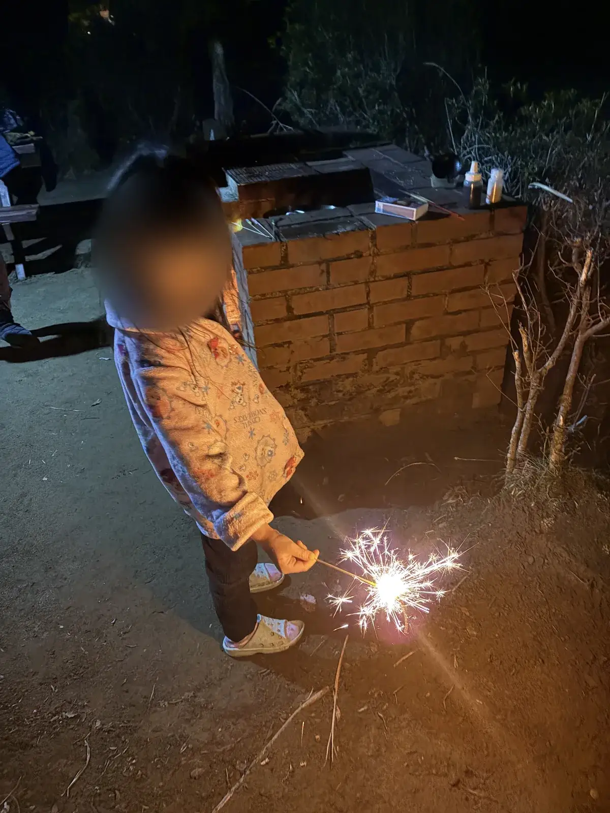 キャンプ場で手持ち花火をする子ども